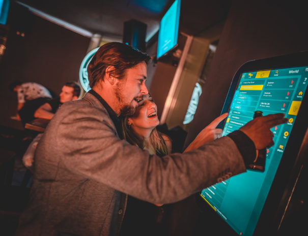 Searching for songs on the touchscreen karaoke jubox at a birthday party
